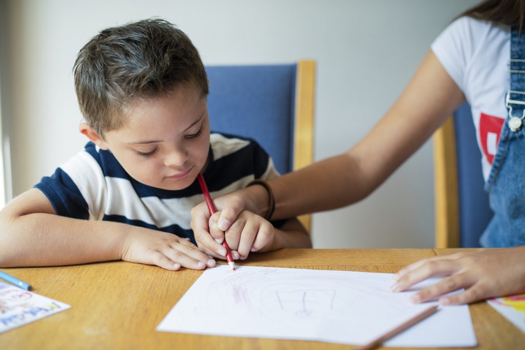 Girl helping her brother to draw