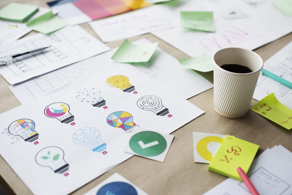 Desk showing multiple items showcasing the process of innovation. 