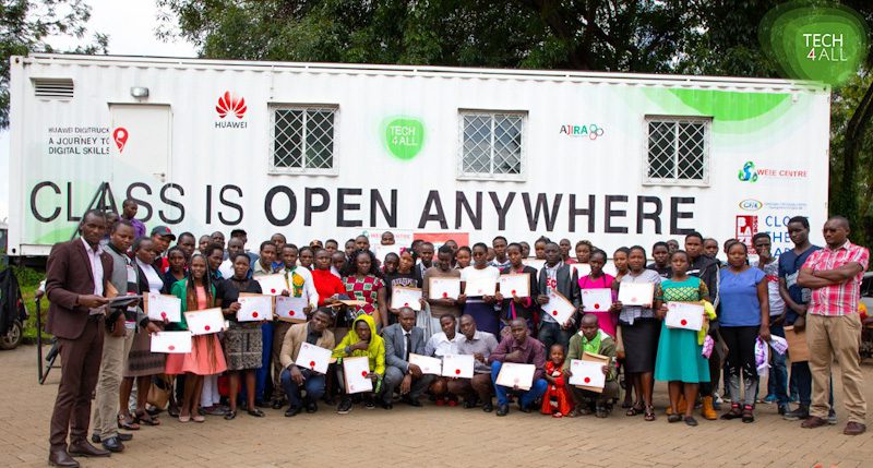 A lot of people posing with certificates in front of the DigiTruck