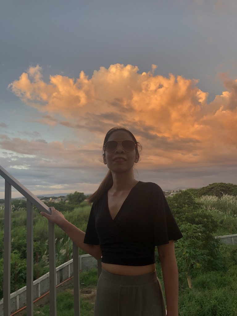 Jasmin Ambiong, smiling with a sunset background.