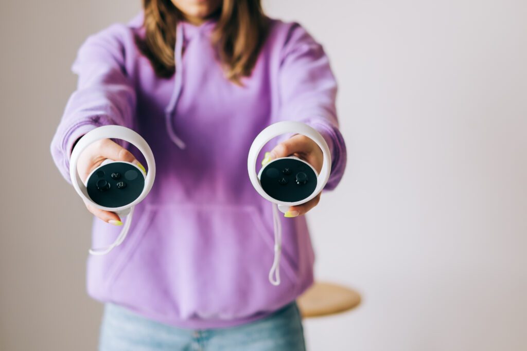Woman holding virtual reality controllers in hands.